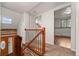 Hallway with wooden railing and log accents leads to bright living spaces, highlighting the home's unique character at 8821 Blue Creek Rd, Evergreen, CO 80439