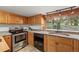 Modern kitchen with stainless steel oven, wood cabinets, and a scenic view at 8821 Blue Creek Rd, Evergreen, CO 80439