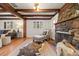Cozy living room with stone fireplace and wooden beam ceiling, creating a warm ambiance at 8821 Blue Creek Rd, Evergreen, CO 80439