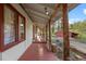 Inviting porch with rustic log columns and views of the landscaped yard and surrounding trees at 8821 Blue Creek Rd, Evergreen, CO 80439