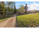 Picturesque view of a home, garage, and sprawling green meadow surrounded by lush trees at 8821 Blue Creek Rd, Evergreen, CO 80439