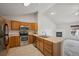 Bright kitchen featuring stainless steel appliances, wood cabinets, and a breakfast bar overlooking the living area at 18080 Becket Dr, Parker, CO 80134