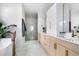 Bathroom featuring dual vanities, a soaking tub, and a glass-enclosed shower at 2524 Zenobia St, Denver, CO 80212