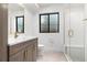 Modern bathroom featuring a glass shower, stylish vanity, and a black-framed window at 2524 Zenobia St, Denver, CO 80212