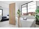 Bright bathroom featuring a soaking tub with gold fixtures and a bedroom visible through an open door at 2524 Zenobia St, Denver, CO 80212