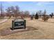 A sign in a park in front of grass and trees. The sign says Sloan's Lake Park at 2524 Zenobia St, Denver, CO 80212