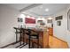 Basement bar area with three bar stools, wood bar, wood flooring, and recessed lighting at 2042 Chesapeake Pl, Highlands Ranch, CO 80126