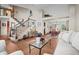 Bright living room with hardwood floors, a staircase, and a dining area in the background at 2042 Chesapeake Pl, Highlands Ranch, CO 80126