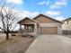 Ranch style home with stone accents, two-car garage, and landscaping at 5242 Longs Peak St, Brighton, CO 80601