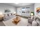 Virtually staged living room with light gray sofa and coffee table at 5242 Longs Peak St, Brighton, CO 80601