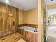Modern bathroom boasts a glass enclosed shower, soaking tub, wood-look tile and bright lighting at 405 Village Rd # 101, Breckenridge, CO 80424