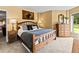 Charming bedroom with a wooden bed frame, patterned pillows, and dresser near window at 405 Village Rd # 101, Breckenridge, CO 80424