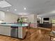 Open kitchen with wood floors, white cabinets, an island and stainless steel dishwasher at 405 Village Rd # 101, Breckenridge, CO 80424
