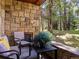 Charming stone patio area with outdoor seating, a lush flower arrangement, and scenic views at 405 Village Rd # 101, Breckenridge, CO 80424