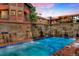 Relaxing pool area with a serene waterfall feature surrounded by beautiful stonework at 405 Village Rd # 101, Breckenridge, CO 80424