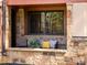 Inviting outdoor porch area with stone accents, comfy seating, and colorful pillows at 405 Village Rd # 101, Breckenridge, CO 80424