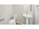 Clean and modern half bathroom with pedestal sink and white toilet at 7312 Watercress Dr, Littleton, CO 80125