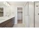 Double vanity bathroom with a large walk-in shower and linen closet at 7312 Watercress Dr, Littleton, CO 80125