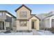 Tan two-story home with stone accents and a front walkway at 7312 Watercress Dr, Littleton, CO 80125