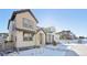 Two-story home with light beige siding and snow-covered walkway at 7312 Watercress Dr, Littleton, CO 80125