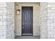 Dark-colored front door with sidelights and stone surround at 7312 Watercress Dr, Littleton, CO 80125