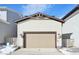 Beige two-car garage with lights and address number at 7312 Watercress Dr, Littleton, CO 80125