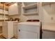 Basement laundry room with washer, dryer, and storage cabinets at 1455 S Vaughn Cir, Aurora, CO 80012