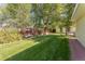 Beautiful backyard with a large grassy area, mature trees, and a wooden fence at 331 Sherman St, Longmont, CO 80501