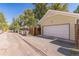 View of a detached garage from the alley featuring a white door and an extended driveway at 331 Sherman St, Longmont, CO 80501