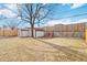 Backyard featuring two sheds, a swing set, mature trees, and a wooden fence at 8481 Dawson Dr, Denver, CO 80229