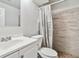 Bright bathroom featuring a single sink vanity and tiled shower with decorative curtain at 8481 Dawson Dr, Denver, CO 80229