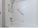 Bathroom tub and shower featuring grab bars, shower head, and tile surround at 7790 W 87Th Drive Dr # D, Arvada, CO 80005
