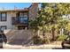 Exterior of the condo shows a private balcony, stone accents, and partial fencing, surrounded by mature landscaping at 7790 W 87Th Drive Dr # D, Arvada, CO 80005