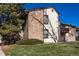 The well-maintained building exterior features a blend of stone accents and siding, enhanced by a lush green lawn at 7790 W 87Th Drive Dr # D, Arvada, CO 80005