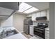 Modern kitchen featuring white cabinets, stainless steel appliances, and a bright skylight for natural illumination at 7790 W 87Th Drive Dr # D, Arvada, CO 80005