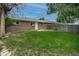 The backyard boasts a lush lawn, brick exterior, mature trees, and a patio area for entertaining at 9320 W 48Th Ave, Wheat Ridge, CO 80033