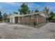 Single-story brick home featuring an attached garage and gravel front yard at 9320 W 48Th Ave, Wheat Ridge, CO 80033