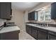 Kitchen featuring dark cabinetry, neutral tile floors, and white tile countertops at 9320 W 48Th Ave, Wheat Ridge, CO 80033