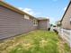 Backyard features a well-maintained lawn, white fence, and ample space for outdoor activities or gardening at 5205 Periwinkle Way, Brighton, CO 80640