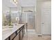 This bathroom features double sinks, modern countertops, and a glass-enclosed shower at 5205 Periwinkle Way, Brighton, CO 80640