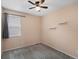 Cozy bedroom features neutral paint, carpet, and a large window with blinds allowing lots of natural light at 5205 Periwinkle Way, Brighton, CO 80640