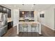 Modern kitchen featuring a large island with seating, stainless steel appliances, and stylish pendant lights at 5205 Periwinkle Way, Brighton, CO 80640