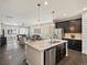 Open-concept kitchen featuring a large island, stainless steel appliances, and seamless flow to the living area at 5205 Periwinkle Way, Brighton, CO 80640