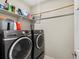 Modern laundry room features front loading washer and dryer and storage shelves for convenience at 5205 Periwinkle Way, Brighton, CO 80640