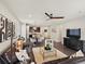 Bright, open-concept living room with modern decor, hardwood floors, and seamless flow to the kitchen at 5205 Periwinkle Way, Brighton, CO 80640