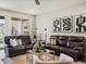 Comfortable living room features plush leather sofas, stylish decor, and ample natural light at 5205 Periwinkle Way, Brighton, CO 80640