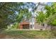 Spacious backyard view features a deck, mature trees, lush lawn, and privacy fencing at 9117 Buck Hill Dr, Highlands Ranch, CO 80126