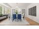 Bright dining room featuring a glass table, blue chairs, and white walls with decorative art at 9117 Buck Hill Dr, Highlands Ranch, CO 80126