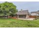 Exterior showcasing a wooden deck, concrete patio, and spacious backyard with mature trees and lawn at 5420 Crestone Cir, Boulder, CO 80301