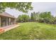 Expansive backyard featuring lush lawn, mature trees, and a sunroom addition to the home at 5420 Crestone Cir, Boulder, CO 80301